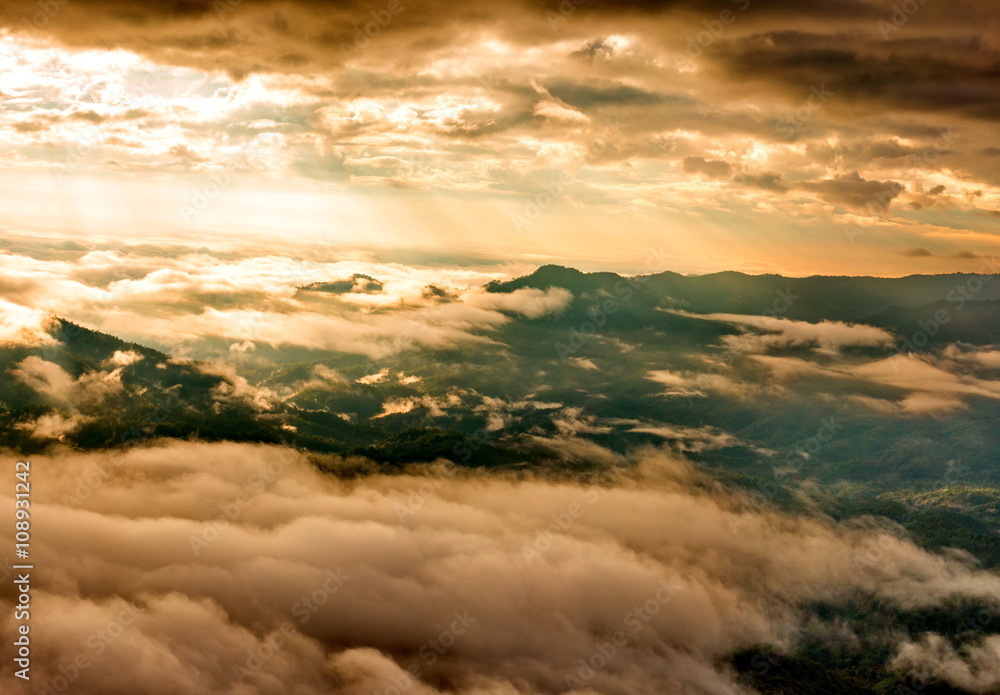 Morning sun shining through the clouds over the mountain Morning sun shining through the clouds over the mountain