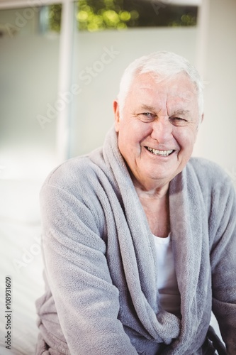 Smiling senior man in bedroom at home