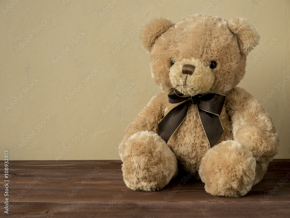 Toy bear sitting on the wooden floor Toy bear sitting on the wooden floor