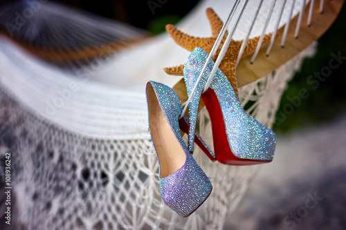 Fotografie Wedding shoes with diamante near starfish over white grid background