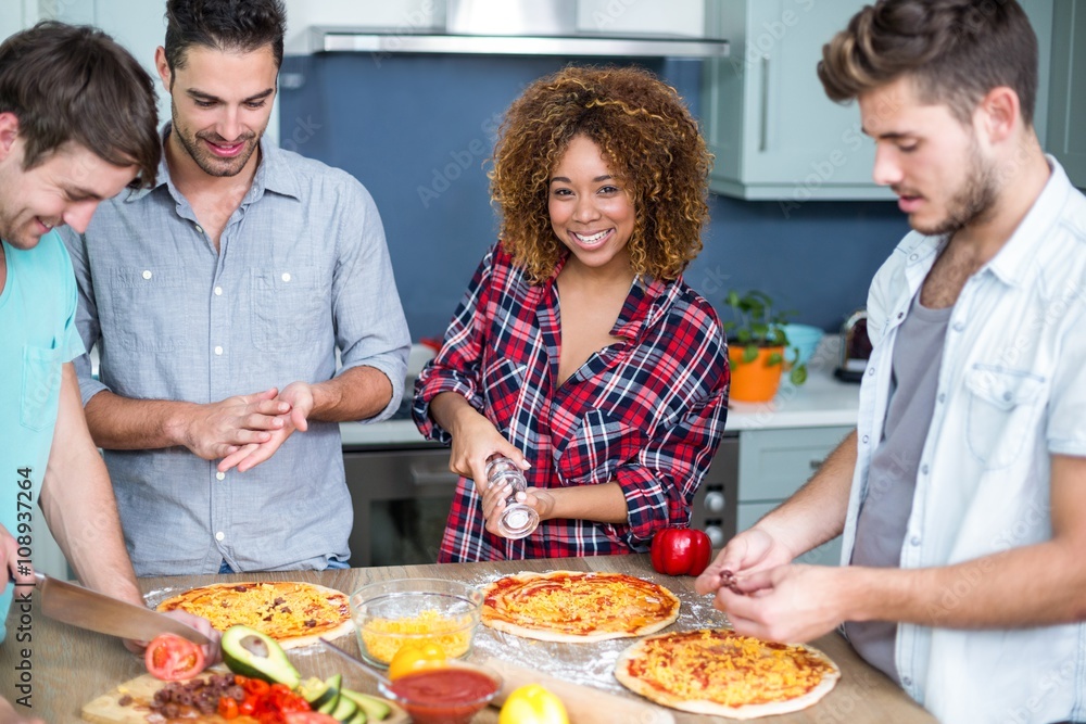 Young woman preparing pizza with friends on table