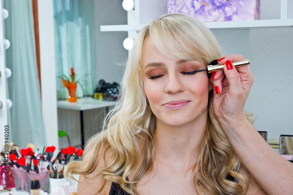 makeup artist applying mascara on womans eyes makeup artist applying mascara on womans eyes