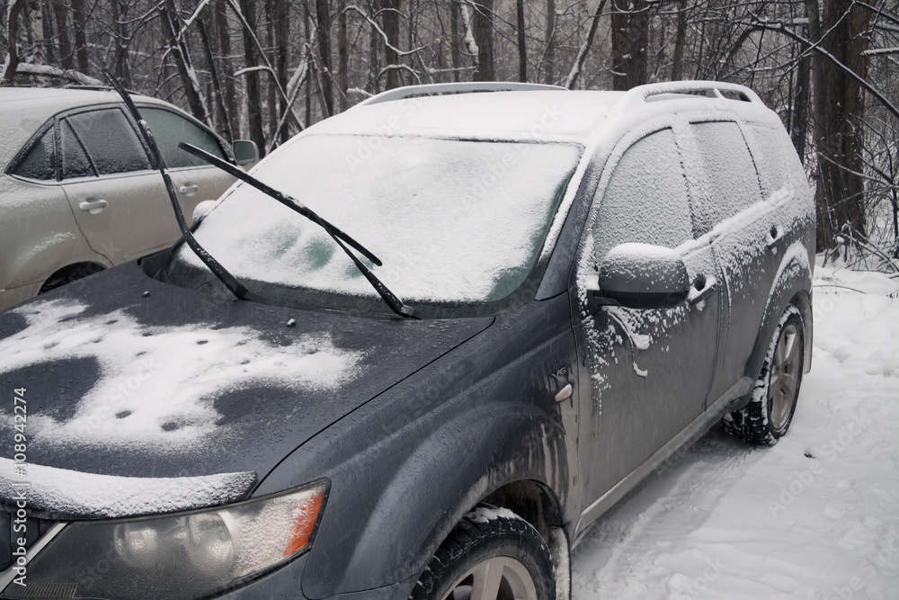 after a strong snow storm car covered in snow