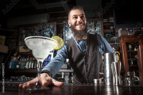 Barman serving cocktail.