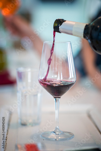 Pouring red wine in wine glass