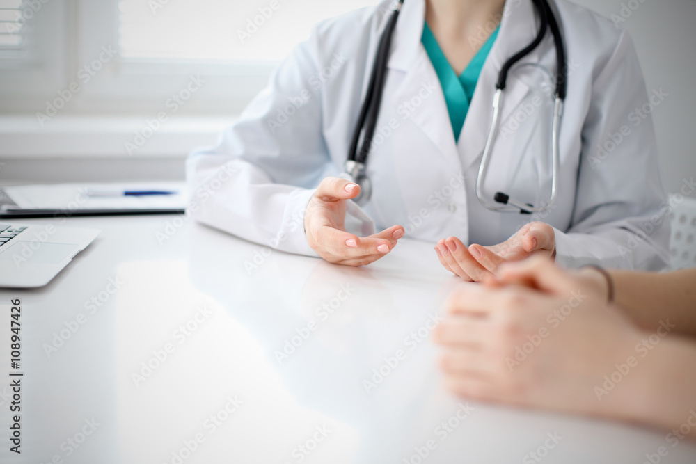 Doctor and patient are discussing something, just hands at the table Doctor and patient are discussing something, just hands at the table