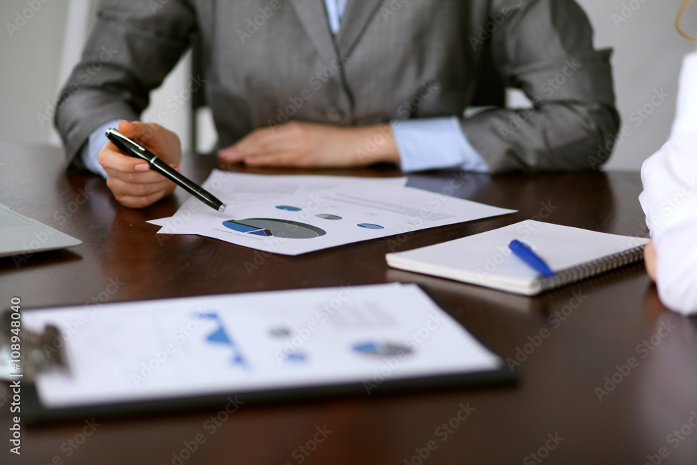 Close up of unknown business people at meeting discussing financial results Close up of unknown business people at meeting discussing financial results