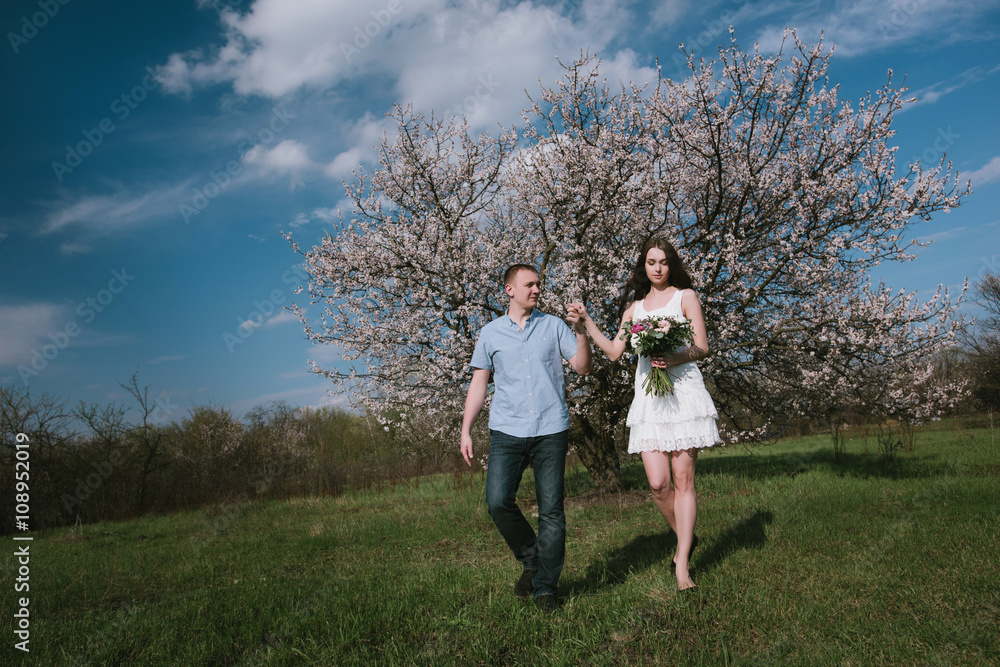Beautiful young couple dancing and having fun on blue sky background in bloom garden,lifestyle
Beautiful young couple dancing and having fun on blue sky background in bloom garden,lifestyle