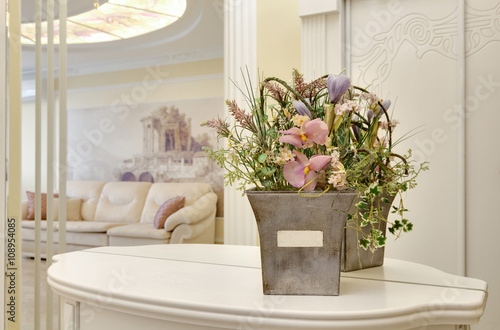 flowers in a pot on a little table