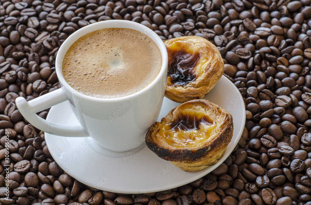 Taza de cafe con pasteles de Belem sobre fondo de granos de cafe Taza de cafe con pasteles de Belem sobre fondo de granos de cafe