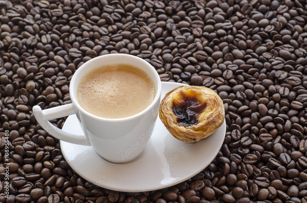 Fototapeta premium Taza de cafe con pastel de Belem sobre fondo de granos de cafe