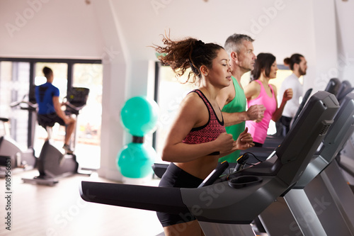 People Using Equipment In Busy Gym