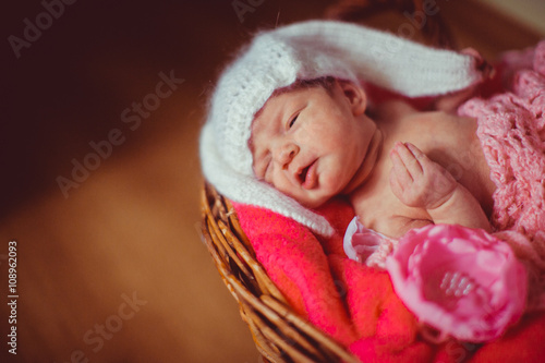 Tiny baby girl in the decorated basket