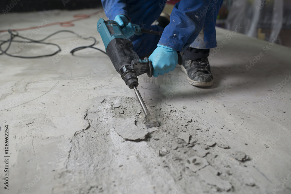 Worker treating the cement floor with a jackhammer Worker treating the cement floor with a jackhammer