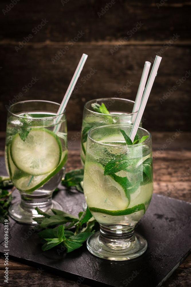 Fototapeta premium detox water with a lemon, lime and mint on a wooden table