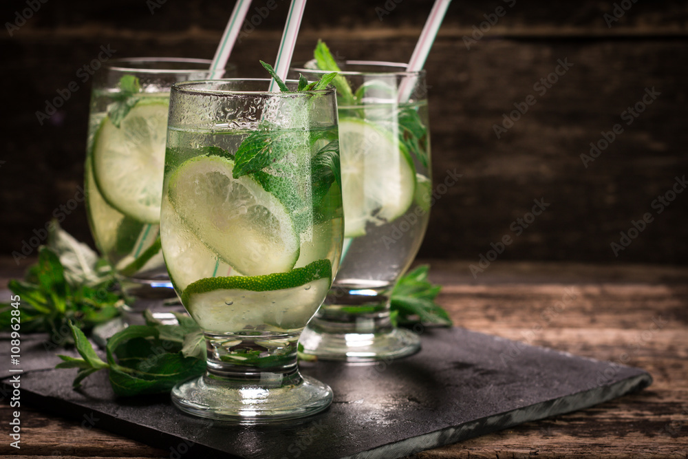 Fototapeta premium detox water with a lemon, lime and mint on a wooden table