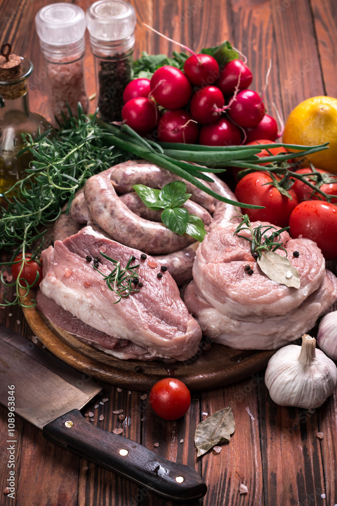 Fresh butcher cut meat assortment garnished with fresh rosemary on wooden table Fresh butcher cut meat assortment garnished with fresh rosemary on wooden table