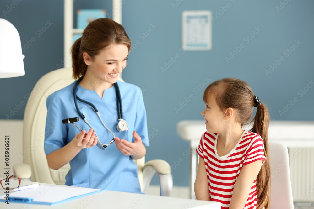 Doctor examining girl with stethoscope in the office Doctor examining girl with stethoscope in the office