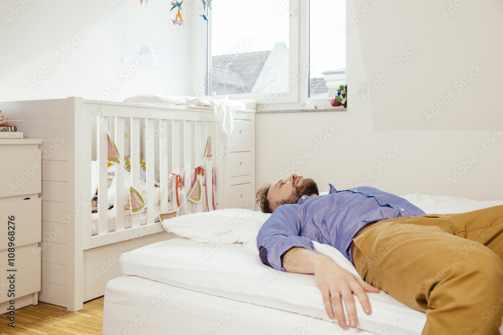 Exhausted father lying down on bed Exhausted father lying down on bed