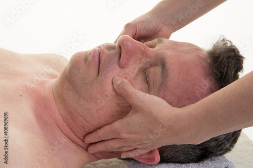 Female therapist applying pressure with thumbs on forehead.