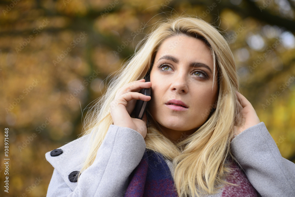 Portrait of young woman in autumn telephoning with smartphone Portrait of young woman in autumn telephoning with smartphone
