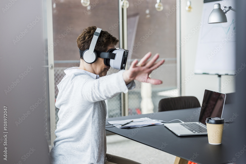 Woman in office wearing virtual reality glasses Woman in office wearing virtual reality glasses