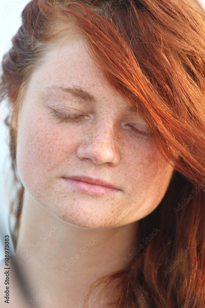 The young girl with red hair, on the tropical island, a sunny day, on a background the sea The young girl with red hair, on the tropical island, a sunny day, on a background the sea