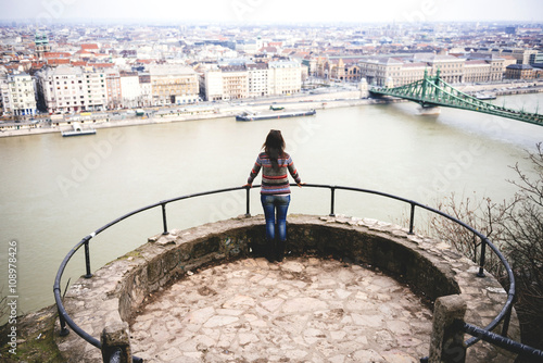 Hungary, Budapest, Woman enjoying the view with Liberty Bridge at Danube river photo