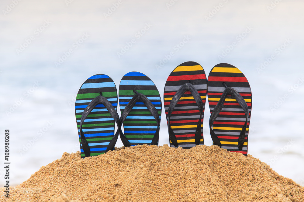 Fototapeta premium Flip flops on the sandy beach