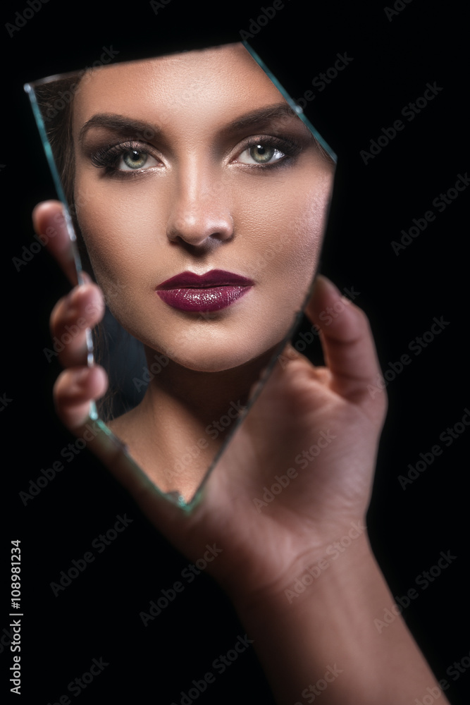 Splinter of mirror with female face in reflection Splinter of mirror with female face in reflection