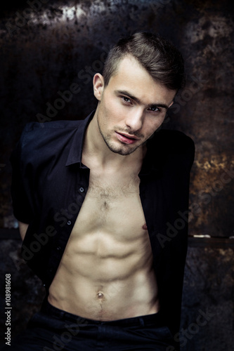 Strong Athletic Man Fitness Model Torso showing six pack abs on dark background © smmartynenko