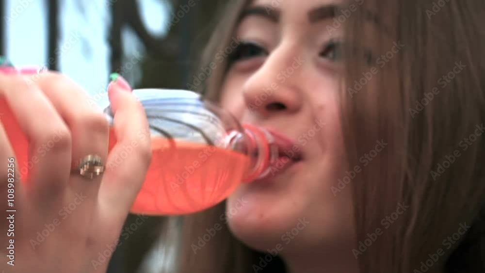 Beautiful woman drinking orange soda. Slow motion. Close up Beautiful woman drinking orange soda. Slow motion. Close up