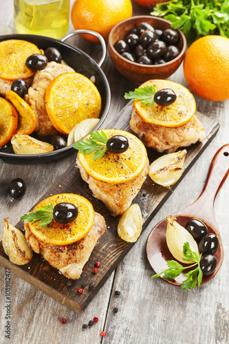 Chicken with oranges and olives on the table