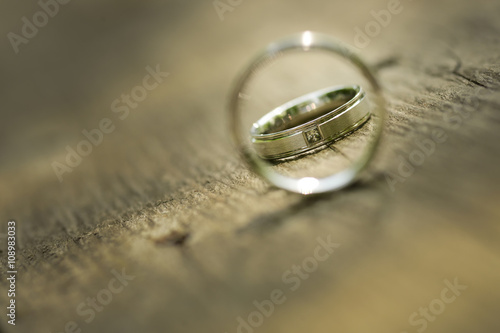 Gold wedding rings placed on a wooden texture