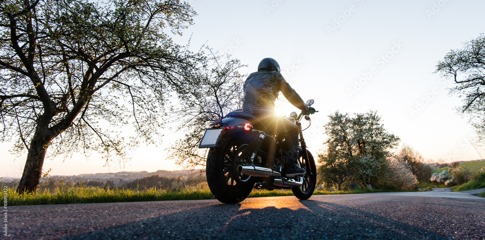 Obraz premium Man seat on the motorcycle on the forest road.