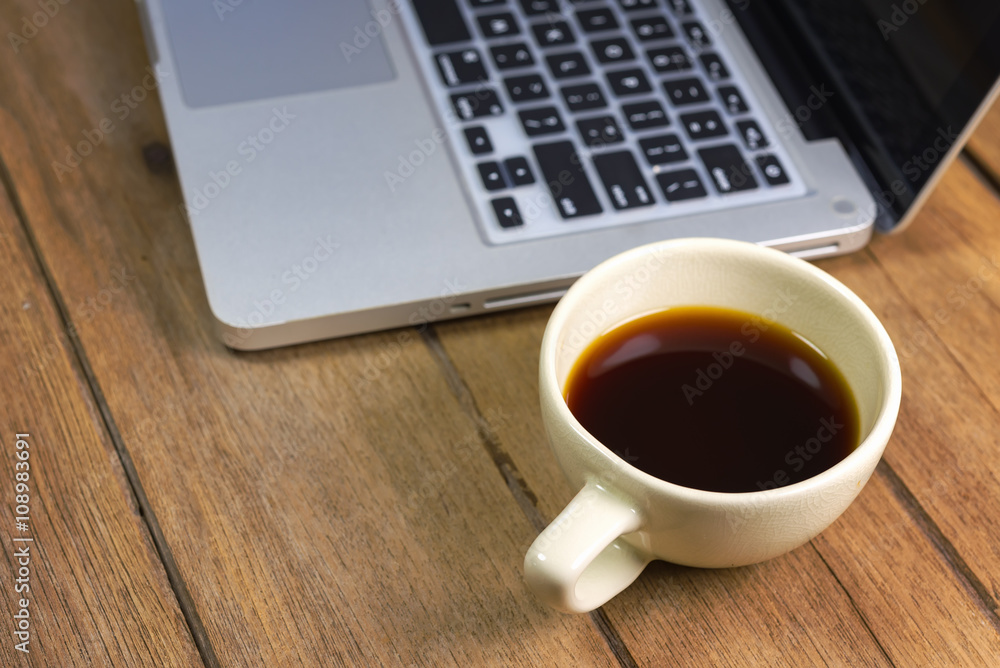 Tablet and hot coffee Americano in cup on old wooden. workspace Tablet and hot coffee Americano in cup on old wooden. workspace