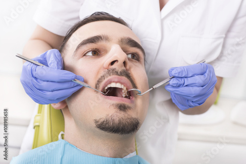 Man having teeth examination at dental clinic. Dentist, doctor, dental care, healthcare. Focus on teeth.