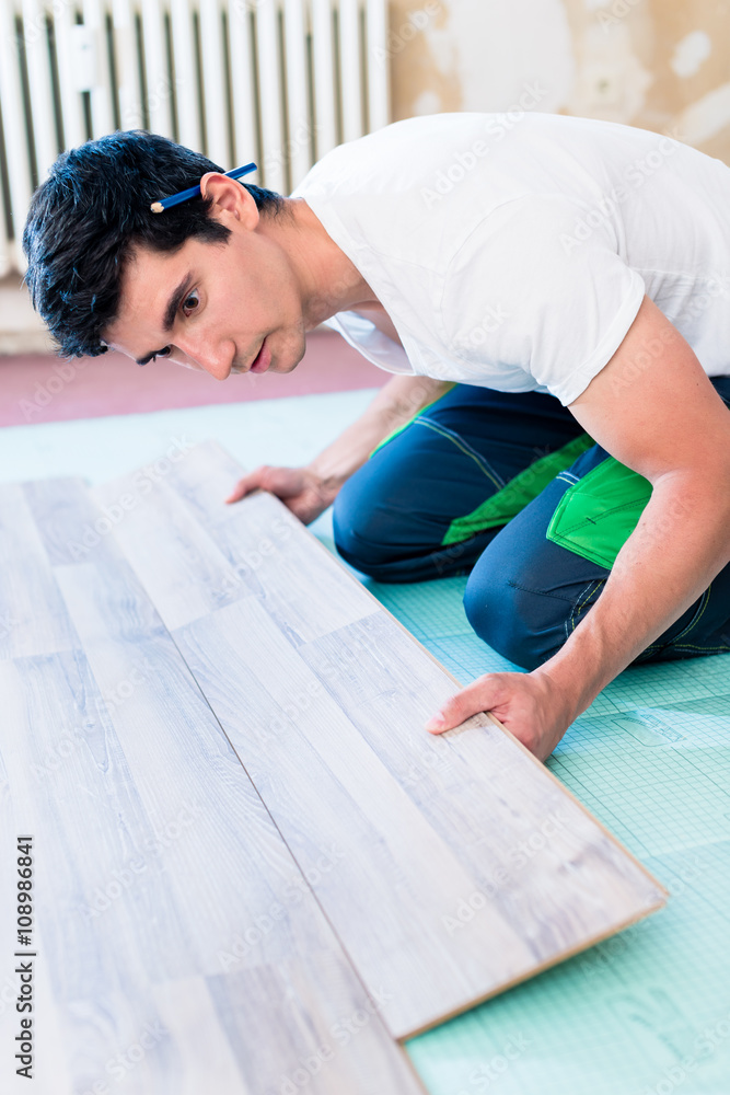 Handwerker legt den Boden in einer Wohnung Handwerker legt den Boden in einer Wohnung