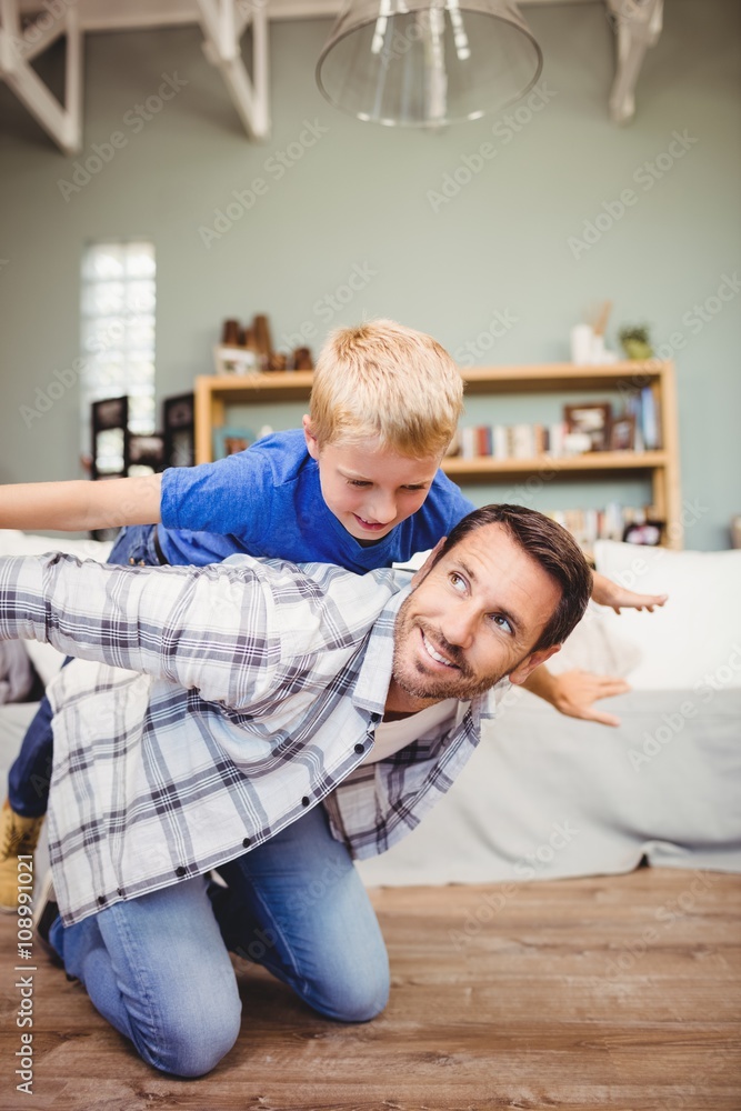 Fototapeta premium Happy father playing with son on hardwood floor