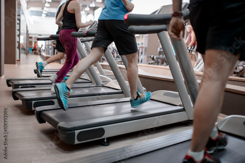 People running in machine treadmill at fitness gym club © Ivan Kurmyshov