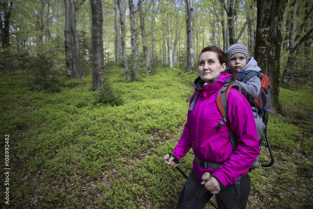 Mom walks in the forest with a child, a child in the children carry. Mom walks in the forest with a child, a child in the children carry.