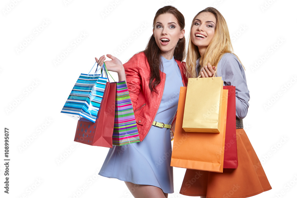 shopping, sale and gifts concept - two smiling  girls 