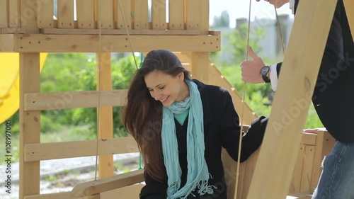 man rolls the girl on a swing. photo