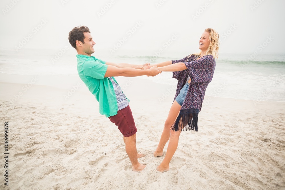 Happy couple holding hands on the beach Happy couple holding hands on the beach