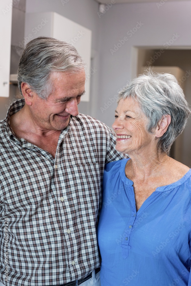 Happy elderly man and woman standing in kitchen Happy elderly man and woman standing in kitchen