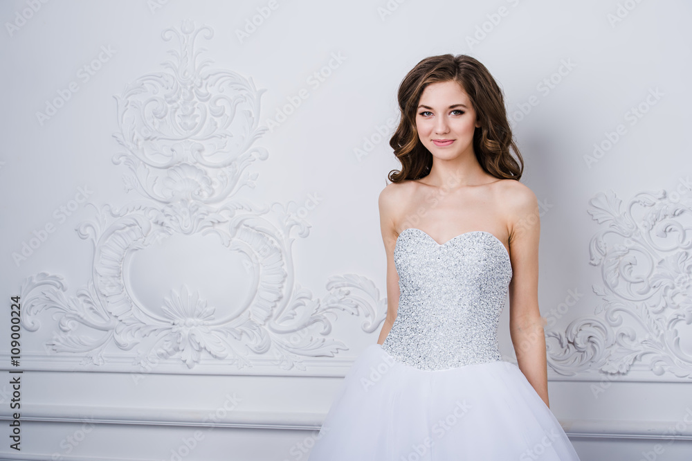 Young beautiful bride standing in antique interior ornamental design done with a moldings. Studio shot Young beautiful bride standing in antique interior ornamental design done with a moldings. Studio shot