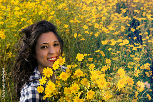 girl having fun among flowers in meadow