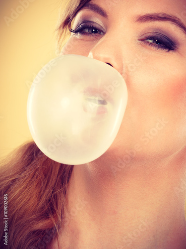 Blonde girl chewing gum making balloon. © anetlanda