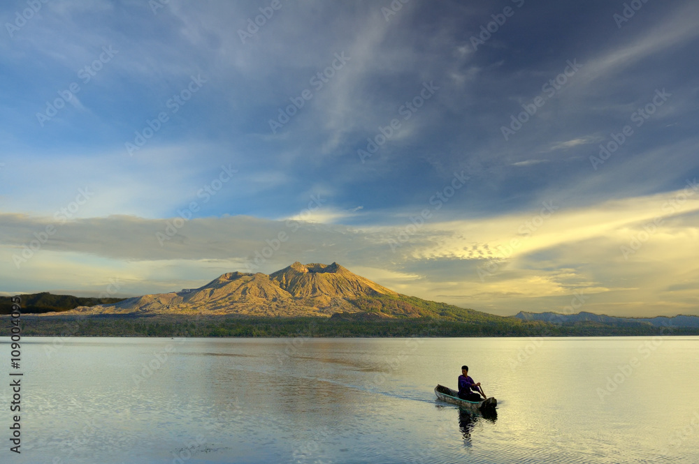 Paddling A Canoe in the Sunrise - person is paddling a canoe in the early morning with beautiful sunrise in the mountain Paddling A Canoe in the Sunrise - person is paddling a canoe in the early morning with beautiful sunrise in the mountain
