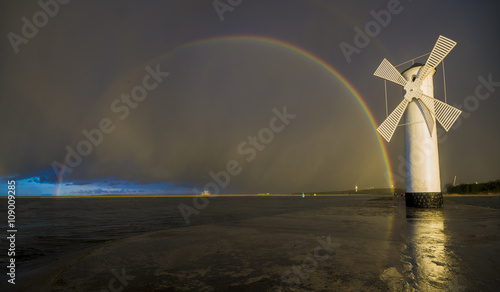 Tęcza nad wiatrakiem po przejściu wieczornej burzy nad morzem © Mike Mareen